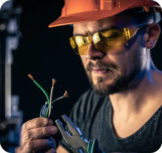 a man in hard hat holding a wire