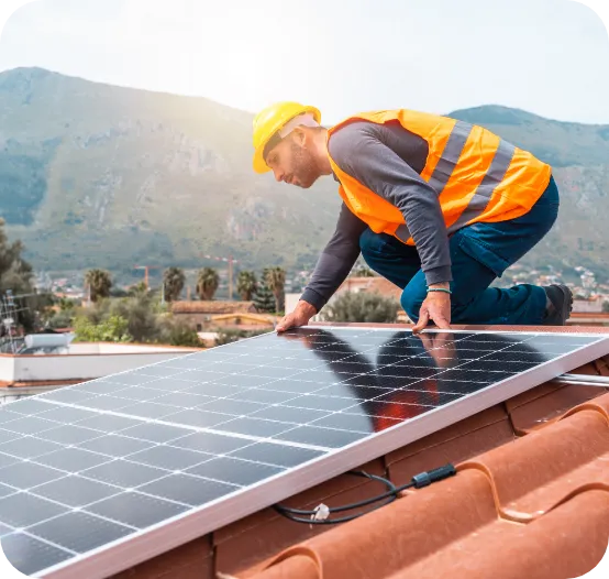 a man in a yellow vest and hard hat working on a solar panel