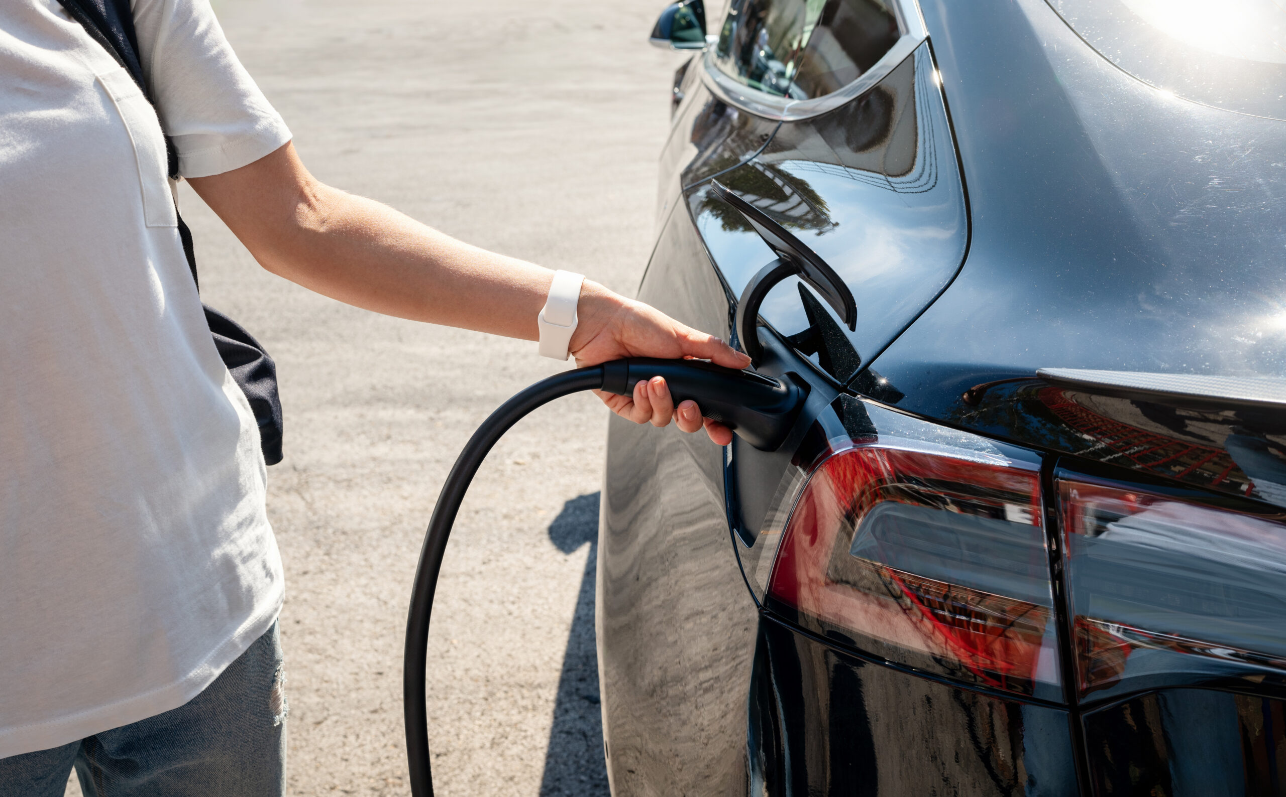 Person plugging an electric vehicle into a home charging port